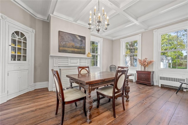 dining space featuring radiator heating unit, beamed ceiling, wood-type flooring, ornamental molding, and coffered ceiling