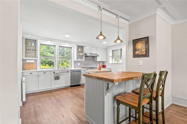 kitchen with wood counters, a breakfast bar, decorative light fixtures, dishwasher, and white cabinets