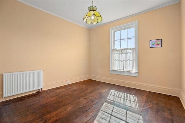 empty room with crown molding, radiator, and dark hardwood / wood-style floors