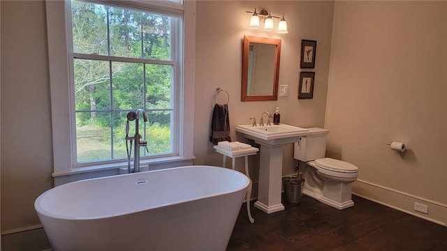 bathroom featuring hardwood / wood-style floors, a bathtub, sink, and toilet