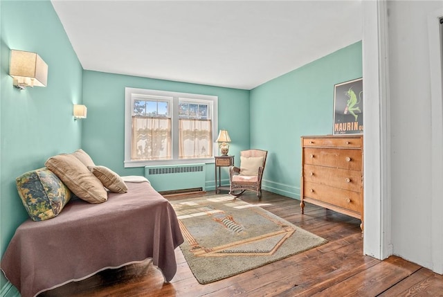 sitting room with hardwood / wood-style floors and radiator heating unit