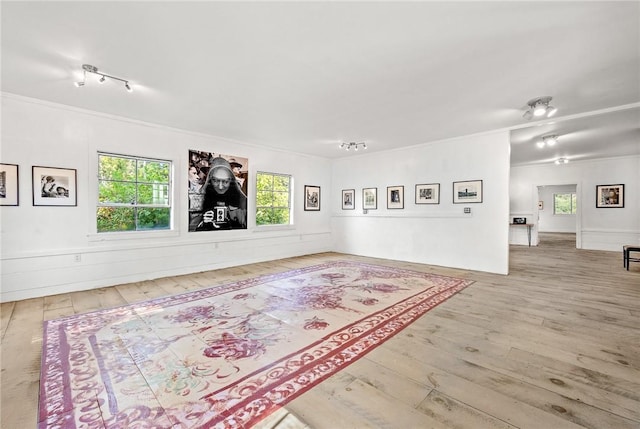 unfurnished room with ornamental molding, wood-type flooring, and track lighting