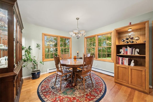 dining space featuring light wood-type flooring, a notable chandelier, and a baseboard heating unit