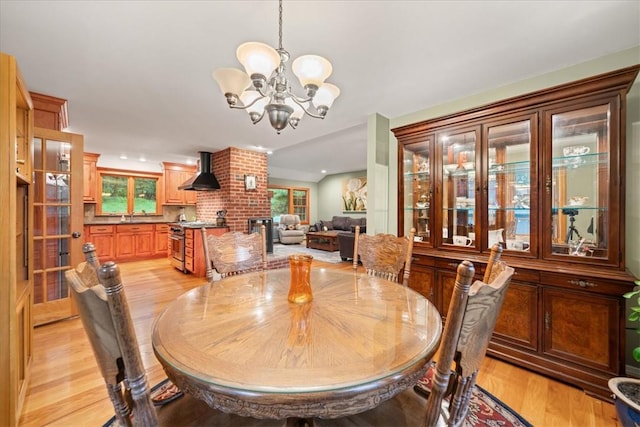 dining room with a notable chandelier, light wood-type flooring, and sink