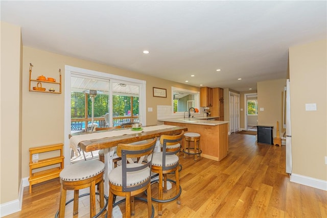 dining space with light hardwood / wood-style flooring and sink