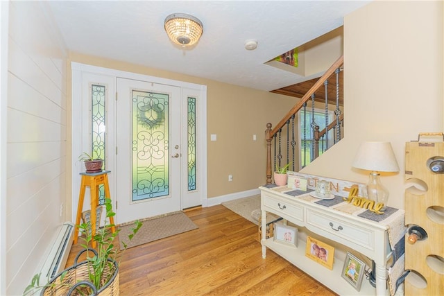 foyer entrance with baseboard heating and light hardwood / wood-style flooring