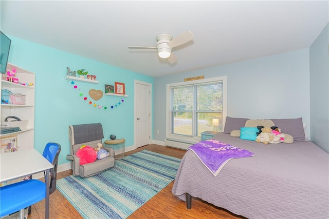 bedroom with ceiling fan, wood-type flooring, and a baseboard radiator