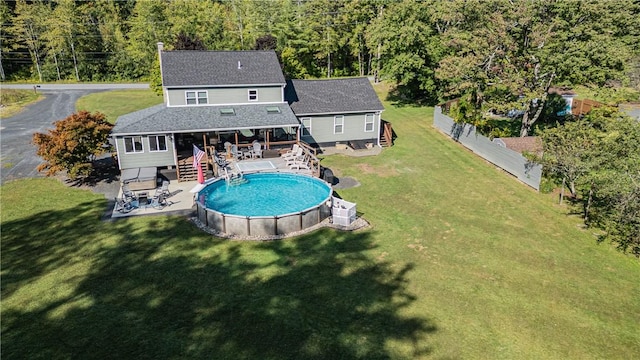 back of house featuring a lawn and a swimming pool side deck