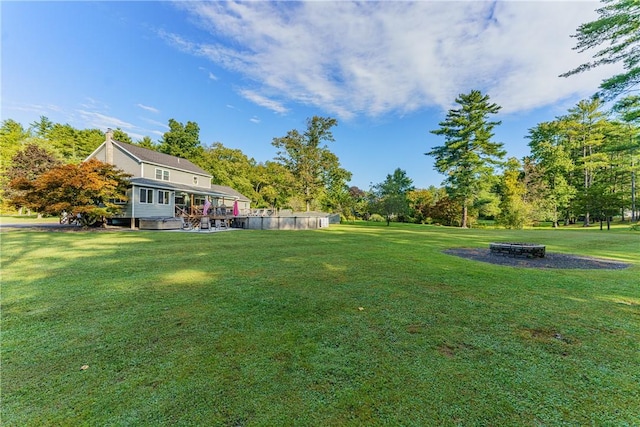 view of yard with a swimming pool and a fire pit