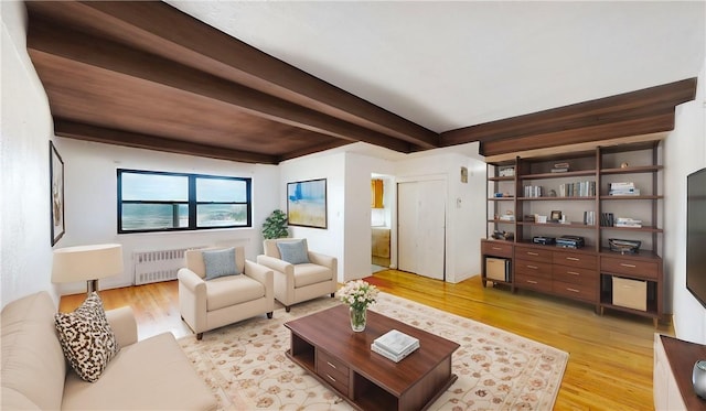 living room featuring beam ceiling, radiator heating unit, and light hardwood / wood-style floors