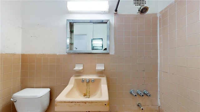 bathroom featuring toilet and tile walls