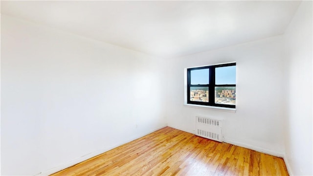 empty room with radiator and light hardwood / wood-style flooring