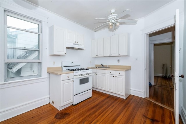 kitchen with white cabinets, dark hardwood / wood-style flooring, radiator, and gas range gas stove