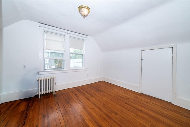 additional living space featuring dark hardwood / wood-style floors, radiator, and lofted ceiling