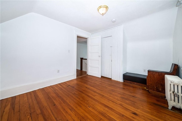 unfurnished bedroom featuring hardwood / wood-style flooring and vaulted ceiling