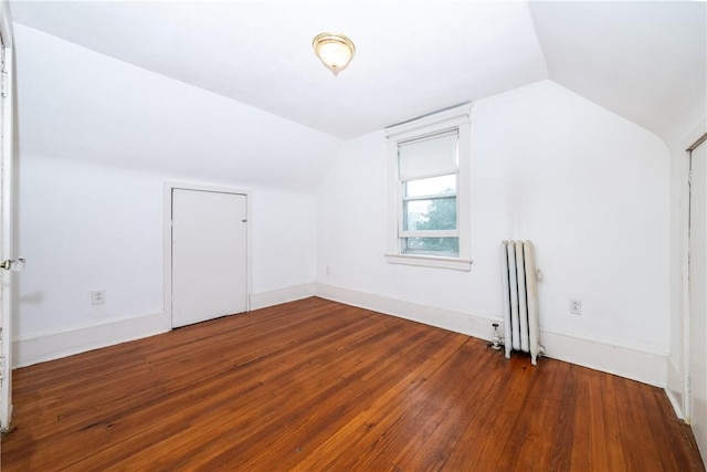 bonus room featuring dark hardwood / wood-style flooring, vaulted ceiling, and radiator