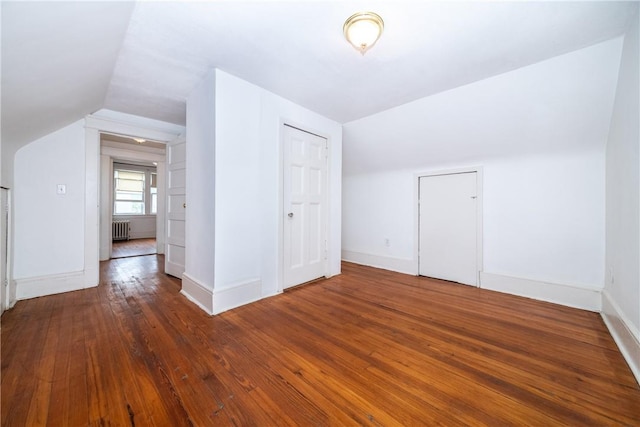 bonus room with vaulted ceiling, radiator, and dark wood-type flooring