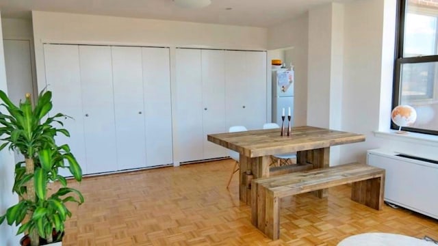 dining area featuring radiator heating unit and light parquet flooring