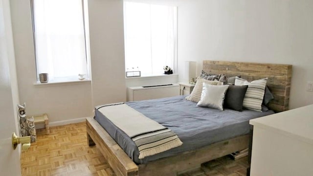 bedroom featuring multiple windows and light parquet floors