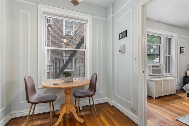 dining area featuring hardwood / wood-style flooring, radiator, and cooling unit