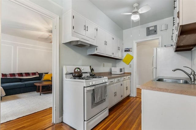 kitchen featuring white cabinetry, ceiling fan, sink, dark hardwood / wood-style flooring, and white appliances