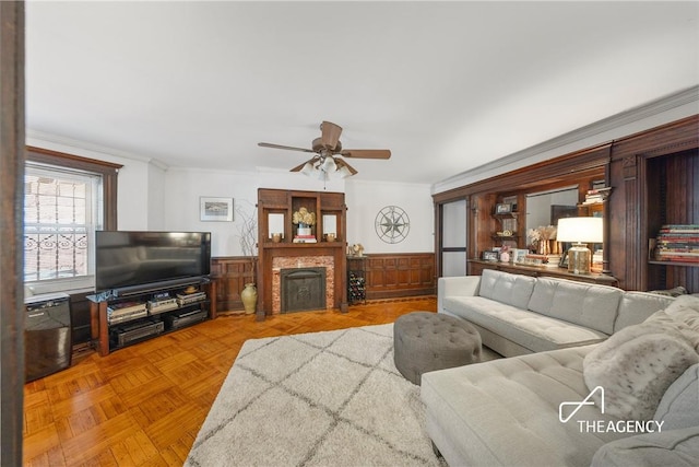 living room with light parquet floors, ceiling fan, and ornamental molding