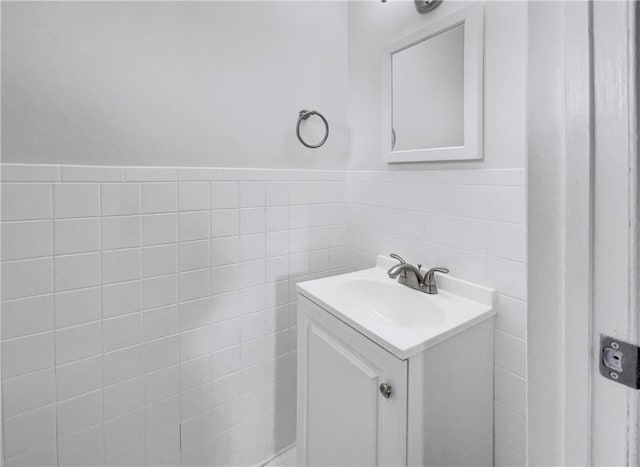 bathroom featuring vanity and tile walls