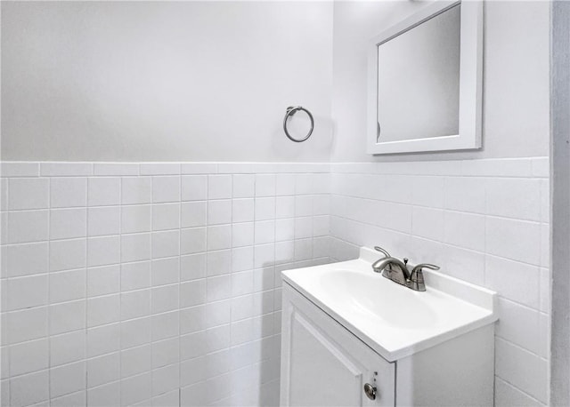 bathroom featuring vanity and tile walls