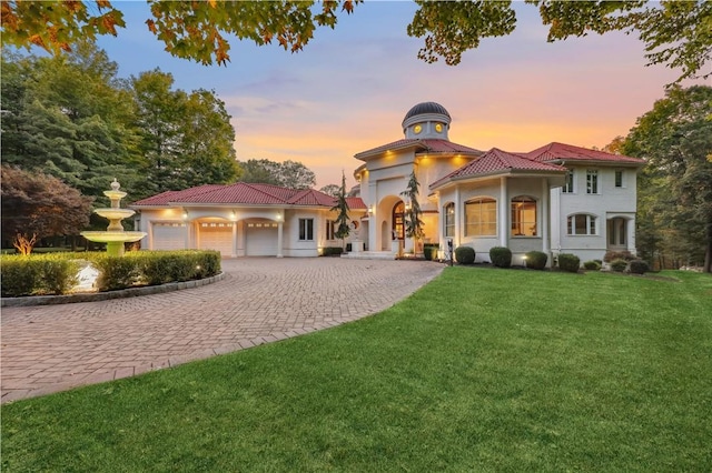 mediterranean / spanish-style home featuring a lawn and a garage