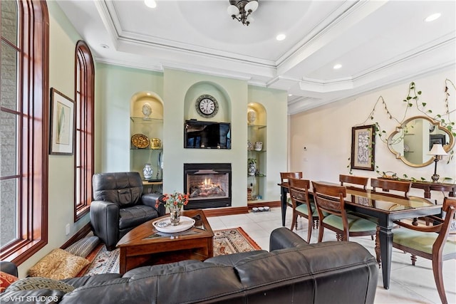 tiled living room with built in shelves, a tray ceiling, and crown molding