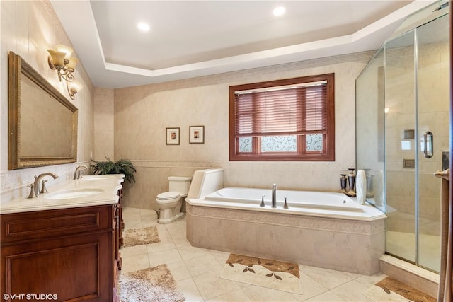 full bathroom with tile patterned flooring, separate shower and tub, toilet, a tray ceiling, and vanity