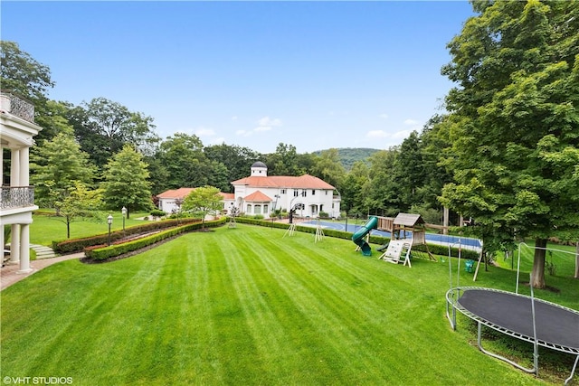 view of yard featuring a playground and a trampoline