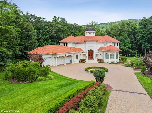 mediterranean / spanish-style house featuring a front lawn and a garage