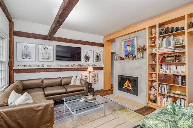 living room featuring beam ceiling, wood-type flooring, and a premium fireplace