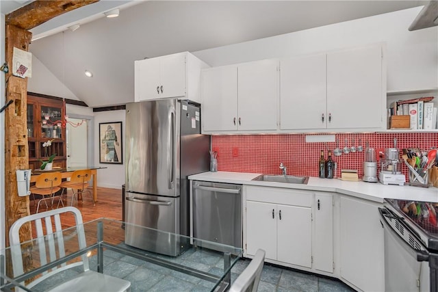 kitchen featuring sink, backsplash, lofted ceiling, white cabinets, and appliances with stainless steel finishes