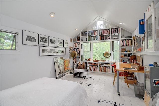 bedroom featuring light wood-type flooring, lofted ceiling, and multiple windows