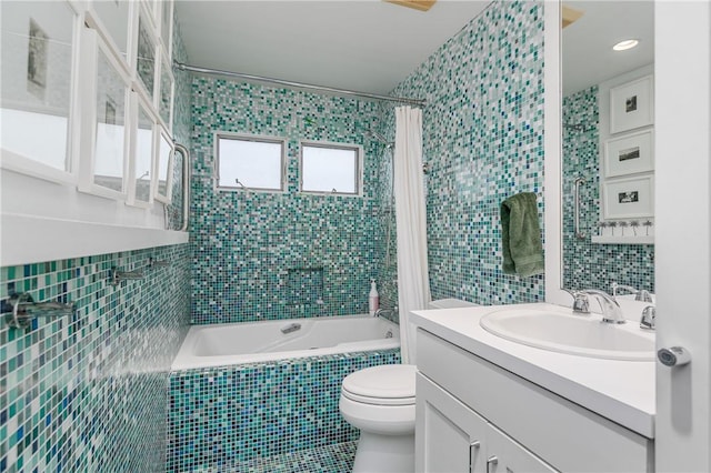 full bathroom with vanity, toilet, tile walls, and shower / tub combo with curtain