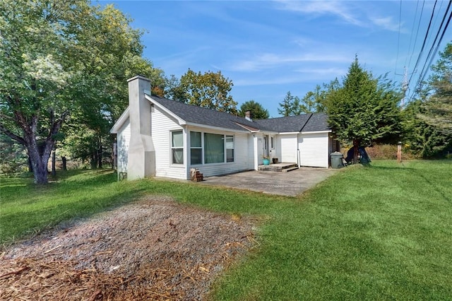 rear view of house featuring a lawn and a patio