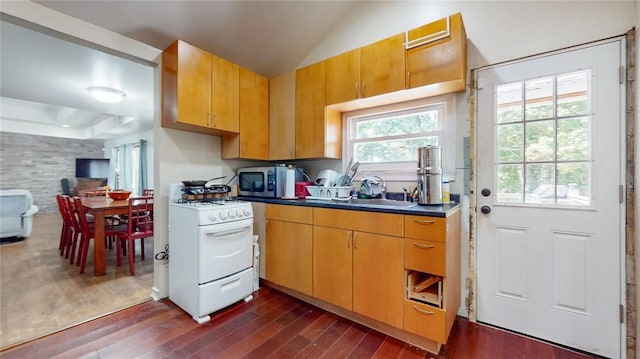 kitchen with white gas stove, dark wood-type flooring, lofted ceiling, and sink