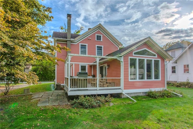 rear view of house featuring a lawn