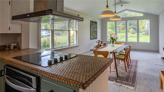 kitchen featuring stainless steel oven, island range hood, a wealth of natural light, and black electric cooktop