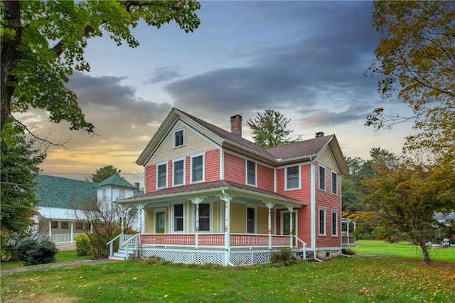 view of front of home featuring a lawn and covered porch