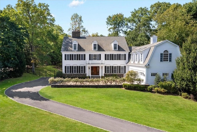 new england style home featuring a front lawn