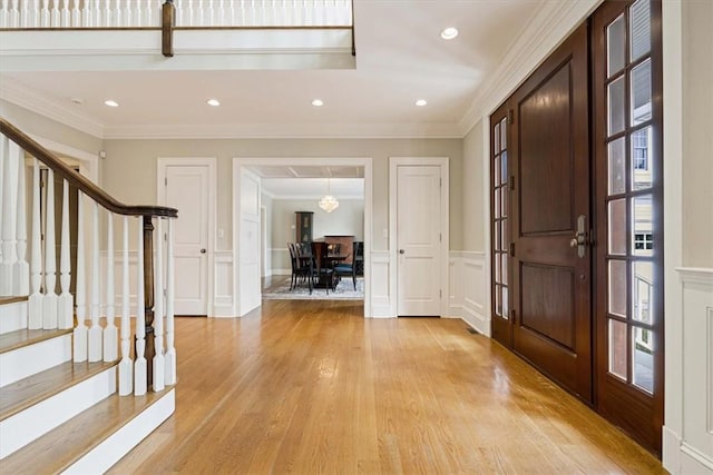 foyer featuring crown molding and light wood finished floors