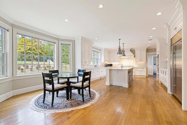 dining room featuring ornamental molding, recessed lighting, baseboards, and light wood finished floors