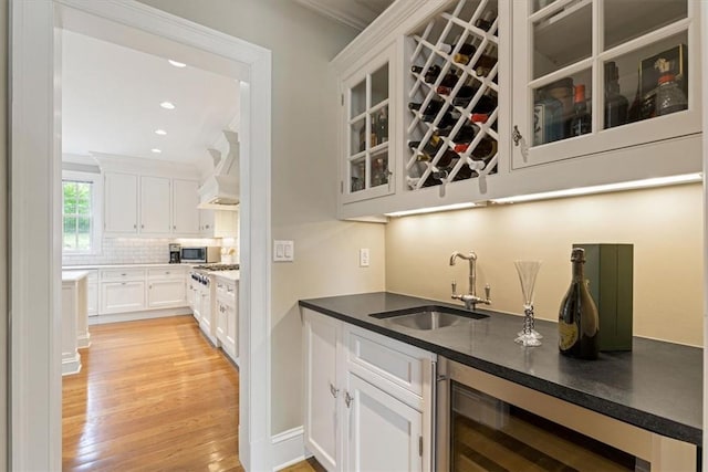 bar with wine cooler, custom range hood, a sink, wet bar, and backsplash