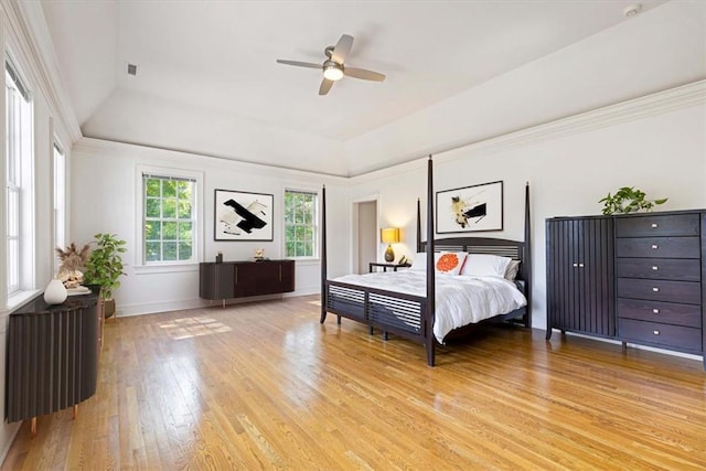 bedroom with visible vents, a raised ceiling, baseboards, ceiling fan, and light wood-style flooring