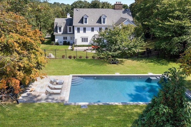 exterior space featuring a fenced in pool, a patio, a fenced backyard, a chimney, and a yard