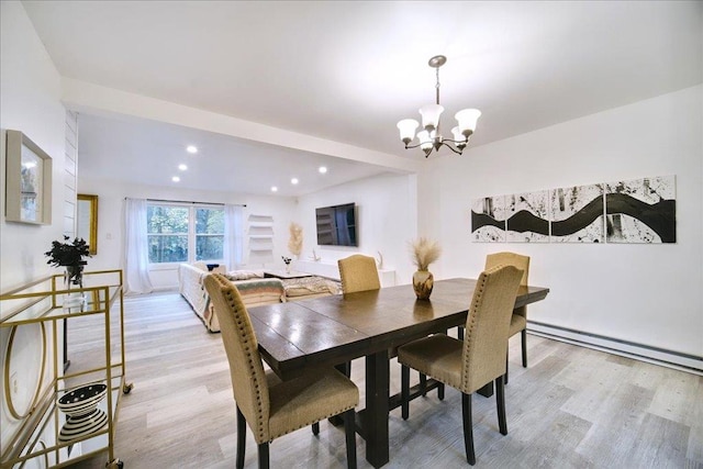 dining room featuring baseboard heating, light hardwood / wood-style flooring, and an inviting chandelier