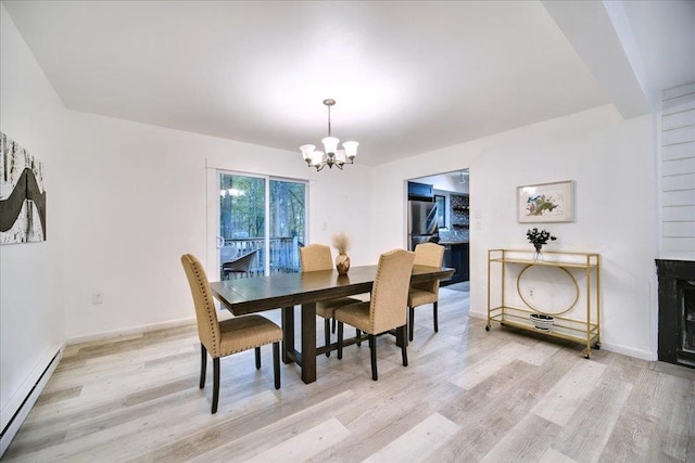 dining room featuring light wood-type flooring, a baseboard radiator, and a notable chandelier